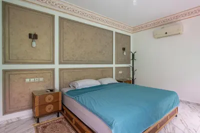 a bedroom with a bed with a blue comforter at Coastal Moroccan Retreat with Ocean Views in Rabat