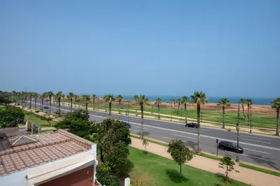 a view of a street with palm trees and a road at Coastal Moroccan Retreat with Ocean Views in Rabat