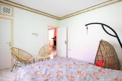a bedroom with a bed with chairs and a table at Coastal Moroccan Retreat with Ocean Views in Rabat