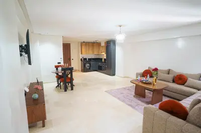 a living room with a couch and a table at Central and Chic Apartment in the Heart of Casablanca Near To Station Tramway Abdelmoumen in Casablanca
