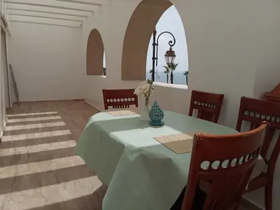 a dining room with a green table and chairs at Chez Basma in Rabat