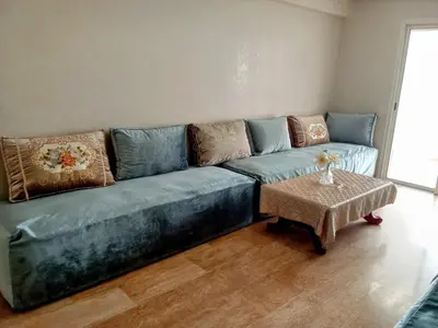 a blue couch in a living room with a table at Chez Basma in Rabat