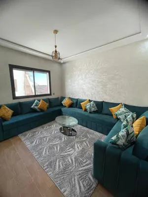 a living room with a blue couch and a table at Apparemment propre pour location pour les familles in Casablanca