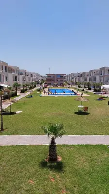 a palm tree in the middle of a park at Location de vacances 3 chambres in Mansouria