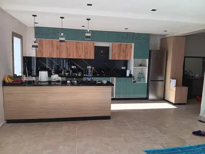a kitchen with a counter and a refrigerator at Location de vacances 3 chambres in Mansouria