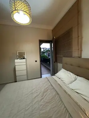 a bedroom with a large bed and a chandelier at Dar al Bahr à Blanca beach Sidi Rehal in Sidi Rahal