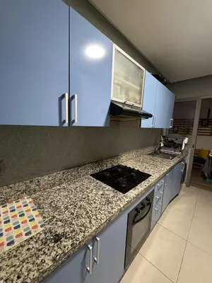 a kitchen with white cabinets and a granite counter top at Dar al Bahr à Blanca beach Sidi Rehal in Sidi Rahal