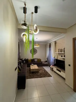 a living room with a couch and a table at Dar al Bahr à Blanca beach Sidi Rehal in Sidi Rahal