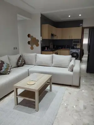 a living room with a white couch and a coffee table at Evasion Prince 1 in Sidi el Haj Bou Derbala