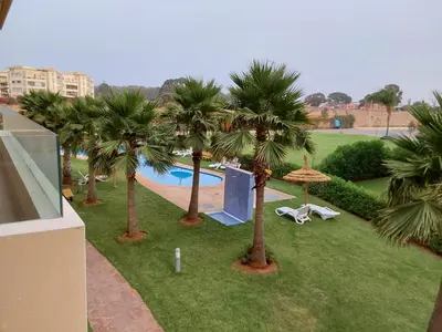 an aerial view of a resort with palm trees and a pool at Evasion Prince 1 in Sidi el Haj Bou Derbala