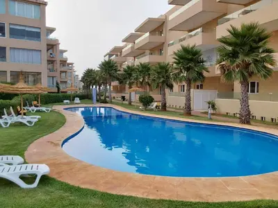 a swimming pool in front of a apartment building at Evasion Prince 1 in Sidi el Haj Bou Derbala