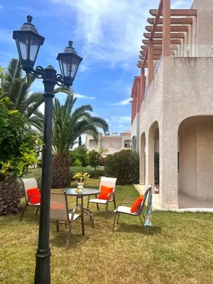 a lampost with chairs and a table and a table with at Villa près de la mer, sidi rahal route de dar bouazza in Bir Jedíd Saint-Hubert