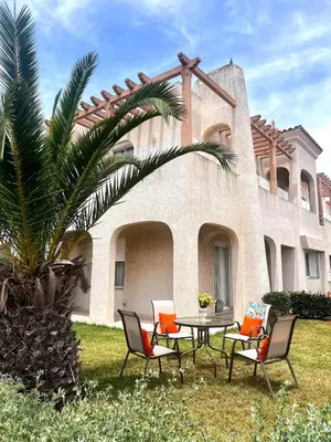 a patio with chairs and a table in front of a house at Villa près de la mer, sidi rahal route de dar bouazza in Bir Jedíd Saint-Hubert