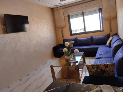 a living room with a blue couch and a tv at Settat, Morocco in Settat