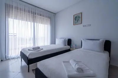 a bedroom with two beds and a large window at Appartement Moderne avec Piscine in Bouznika