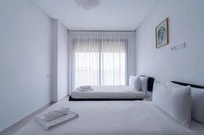 a white room with a bed and a window at Appartement Moderne avec Piscine in Bouznika