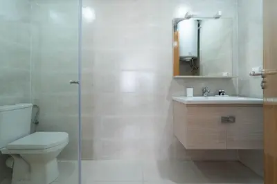 a bathroom with a toilet and a sink and a shower at Appartement Moderne avec Piscine in Bouznika