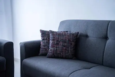 a blue couch with a pillow on top of it at Appartement Moderne avec Piscine in Bouznika
