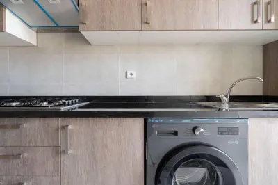 a kitchen with a sink and a washing machine at Appartement Moderne avec Piscine in Bouznika