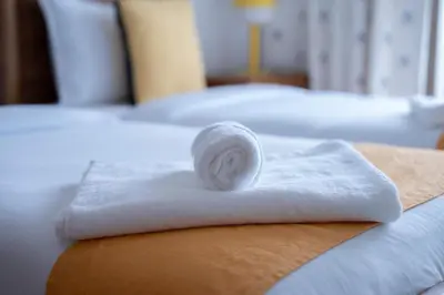 a roll of towels sitting on top of a bed at Détente en Famille, Piscine, Plage à Proximité in Bouznika
