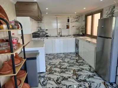 a kitchen with a marble floor and a refrigerator at Farm - Private pool - Games - Nature in El Jadida