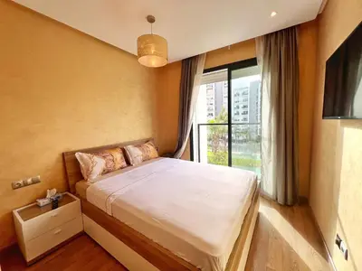 a bedroom with a bed and a large window at Elegant & Spacious Apartment in Prestigia in Rabat