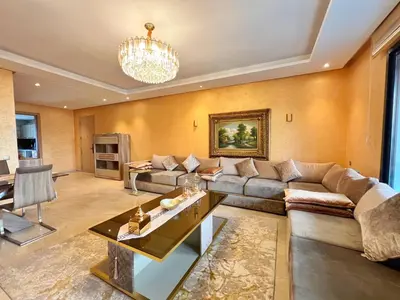 a living room with a couch and a table at Elegant & Spacious Apartment in Prestigia in Rabat