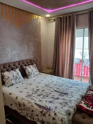 a bedroom with a large bed with a purple ceiling at Appartement bouznika in Bouznika