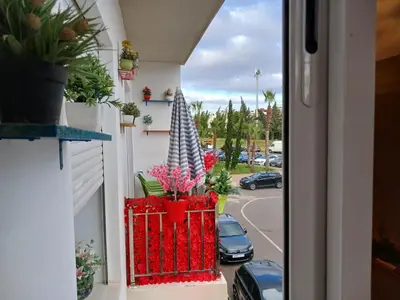 a balcony with potted plants on the side of a building at Appartement bouznika in Bouznika