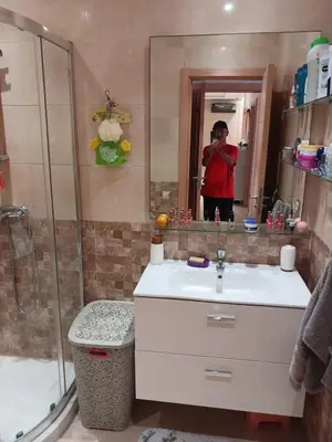 a man taking a picture in a bathroom mirror at Appartement bouznika in Bouznika