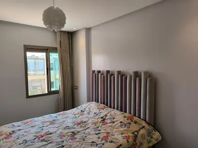 a bedroom with a bed and a radiator and a window at Les Sables de Sidi Rahal - Blue Beach in Sidi Rahal
