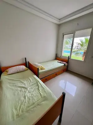 a bedroom with two beds and a window at OlaBlanca2, appartement avec terrasse et vue sur piscine in Sidi Rahal