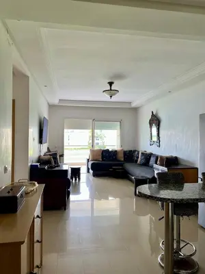 a living room with a couch and a table at OlaBlanca2, appartement avec terrasse et vue sur piscine in Sidi Rahal