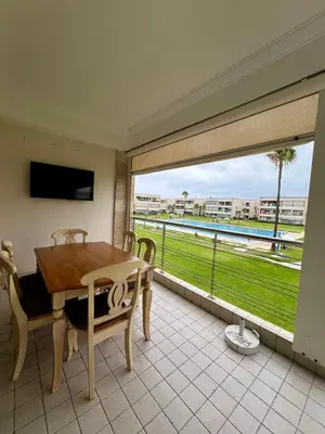 a dining room with a table and a large window at OlaBlanca2, appartement avec terrasse et vue sur piscine in Sidi Rahal