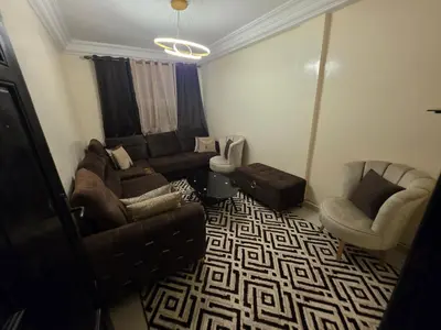 a living room with a couch and two chairs at Appartement Souka Fitness in Bouznika