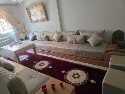 a living room with a couch and a table at Appartement Souka Fitness in Bouznika