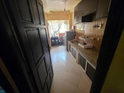 a kitchen with a door open to a kitchen with a sink at Appartement Souka Fitness in Bouznika