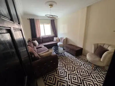 a living room with a couch and a chair at Appartement Souka Fitness in Bouznika