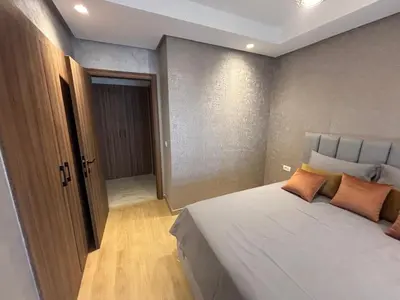 a bedroom with a large white bed with orange pillows at Studio calme à Zenata in Aïn Harrouda