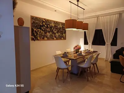a dining room with a table and chairs at Superbe duplex avec vue mer in Aïn Harrouda