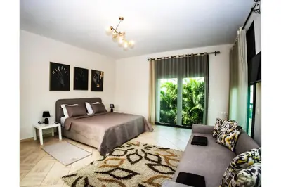 a bedroom with a bed and a couch at Villa avec piscine et sauna 8 chambres proche commodité et Casa Finance City in Casablanca