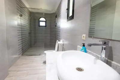 a bathroom with a white sink and a shower at Villa avec piscine et sauna 8 chambres proche commodité et Casa Finance City in Casablanca