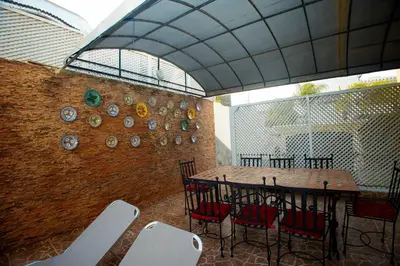 a room with a table and chairs and a brick wall at Villa avec piscine et sauna 8 chambres proche commodité et Casa Finance City in Casablanca