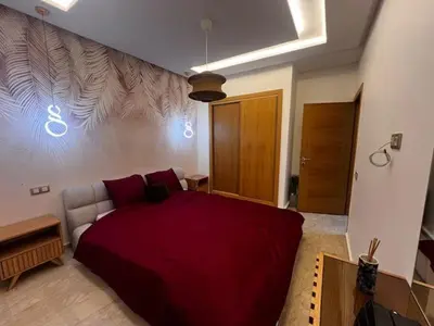 a bedroom with a red bed in a room at Appartement de luxe avec parking gratuit à Casablanca, Vue & Confort in Aïn Sebaa