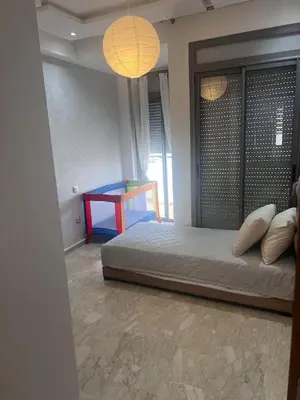 a bedroom with a bed and a table in it at Appartement de luxe avec parking gratuit à Casablanca, Vue & Confort in Aïn Sebaa