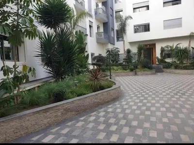 a courtyard in front of a building with plants at Appartement de luxe avec parking gratuit à Casablanca, Vue & Confort in Aïn Sebaa