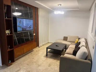 a living room with a couch and a tv at Appartement de luxe avec parking gratuit à Casablanca, Vue & Confort in Aïn Sebaa