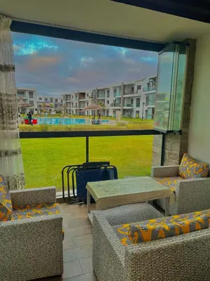 a balcony with couches and a table and a view of a building at Residence Bleu Dhalia in Sidi Rahal