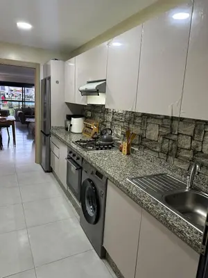 a kitchen with a sink and a washing machine at Residence Bleu Dhalia in Sidi Rahal