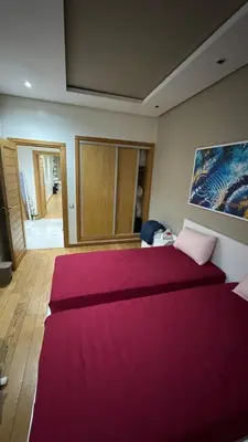 a bedroom with a large bed with a red blanket at Jnane californie in Casablanca